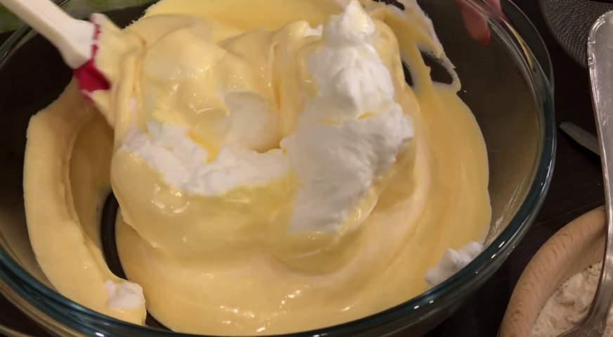 Лимонный торт: Пару ложек белка добавляем во взбитые желтки, и аккуратно перемешиваем.