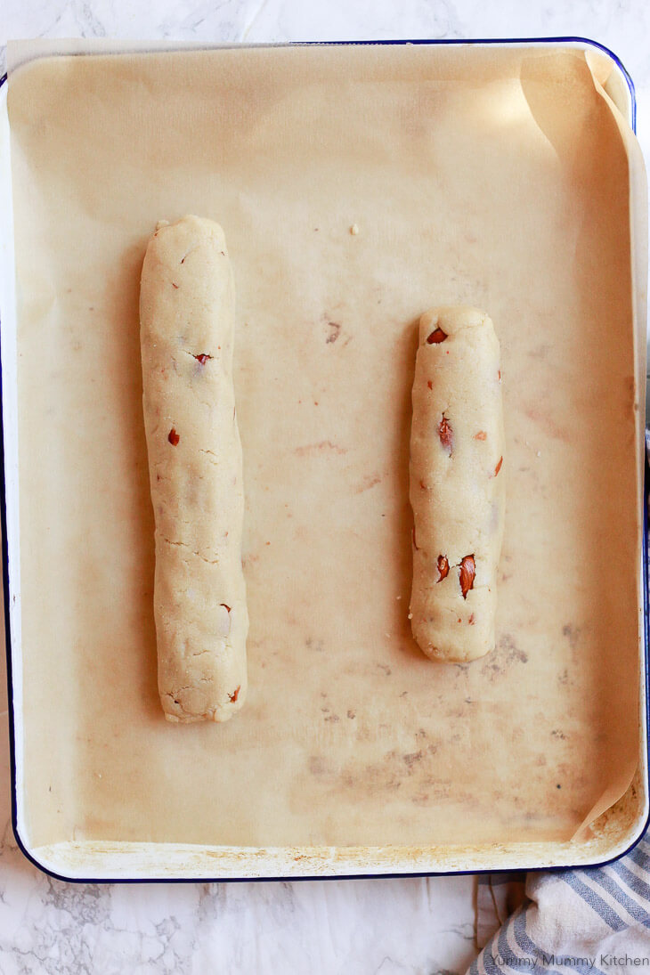 Logs of gluten free almond biscotti dough on a cookie sheet before the first baking. 