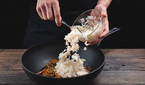 Перекладывание отварного риса в сковороду с заготовкой для риса по-тайски