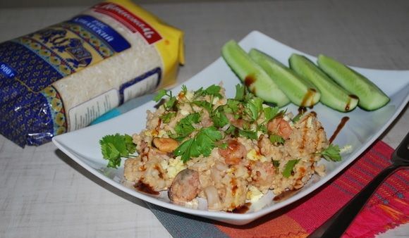 Рис по-тайски с морепродуктами и свежей кинзой на прямоугольной белой тарелке