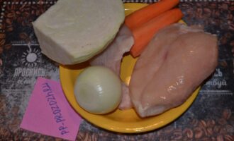 Шаг 1: Подготовьте ингредиенты: капусту, морковь, лук и курицу. Можно использовать и одну грудку, увеличив ее объем до 600 грамм. 