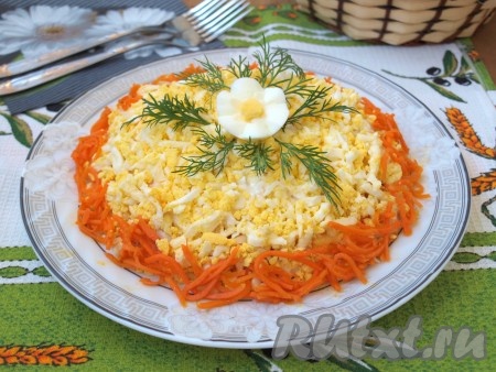 Посыпать салат с курицей и морковью по-корейски натёртыми яйцами и украсить вокруг корейской морковью.
