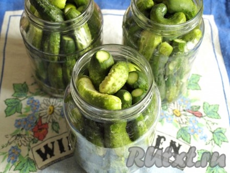 Банки тщательно вымыть, на дно сложить все специи. Если листья хрена крупные, то достаточно положить один лист на литровую банку. Зонтики укропа тоже кладите по размеру - если крупные, то достаточно 1, поменьше - 2. Стебли тоже нужно порезать и положить на дно. Наполнить банки огурцами.