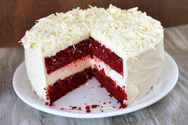 red velvet cheesecake cake on a white plate sliced open to see the inside